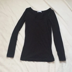 - En svart basictop i stretch. Likadan som den gråa tröjan som finns upplagd tidigare. 