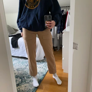 Beiga cargobyxor - Säljer älskade högmidjade cargobyxor, rätt så välanvända och är därför lite noppriga runt midjan. Klotet på nakd och har en super snygg passform! Jag är 173cm lång