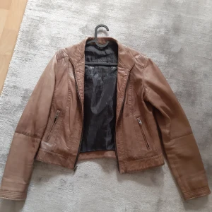 Big L - Superfin äkta läderjacka i storlek 36. Sparsamt använd, men materialet är mjukt och har en vintagefeel. Något kortare modell. Fickor med dragkedja samt en ficka på insidan. Frakt betalas av köparen alt hämtas i Uppsala. Nypris 3200kr.