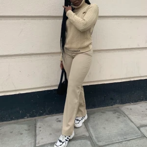 Dolce & Gabbana tröja - Beige stickad polotröja med Dolce & Gabbana logga längst ner på tröjan och en vid bröstet. Passa XS men också S/M.