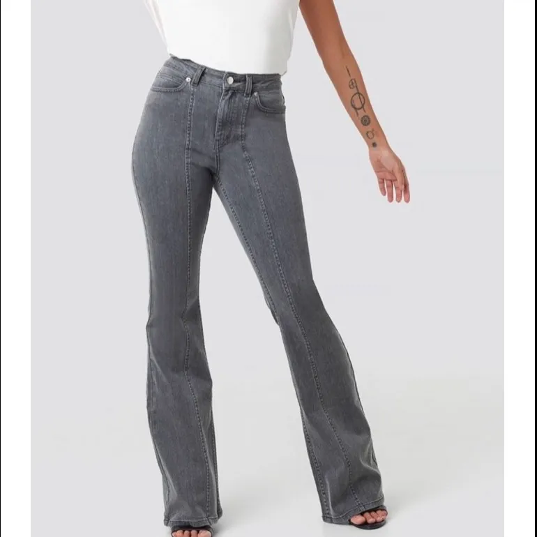 Fina gråa flare jeans från AFJxNAKD. Använda fåtal gånger, säljer då dem inte passar längre. Nyskick!!. Jeans & Byxor.