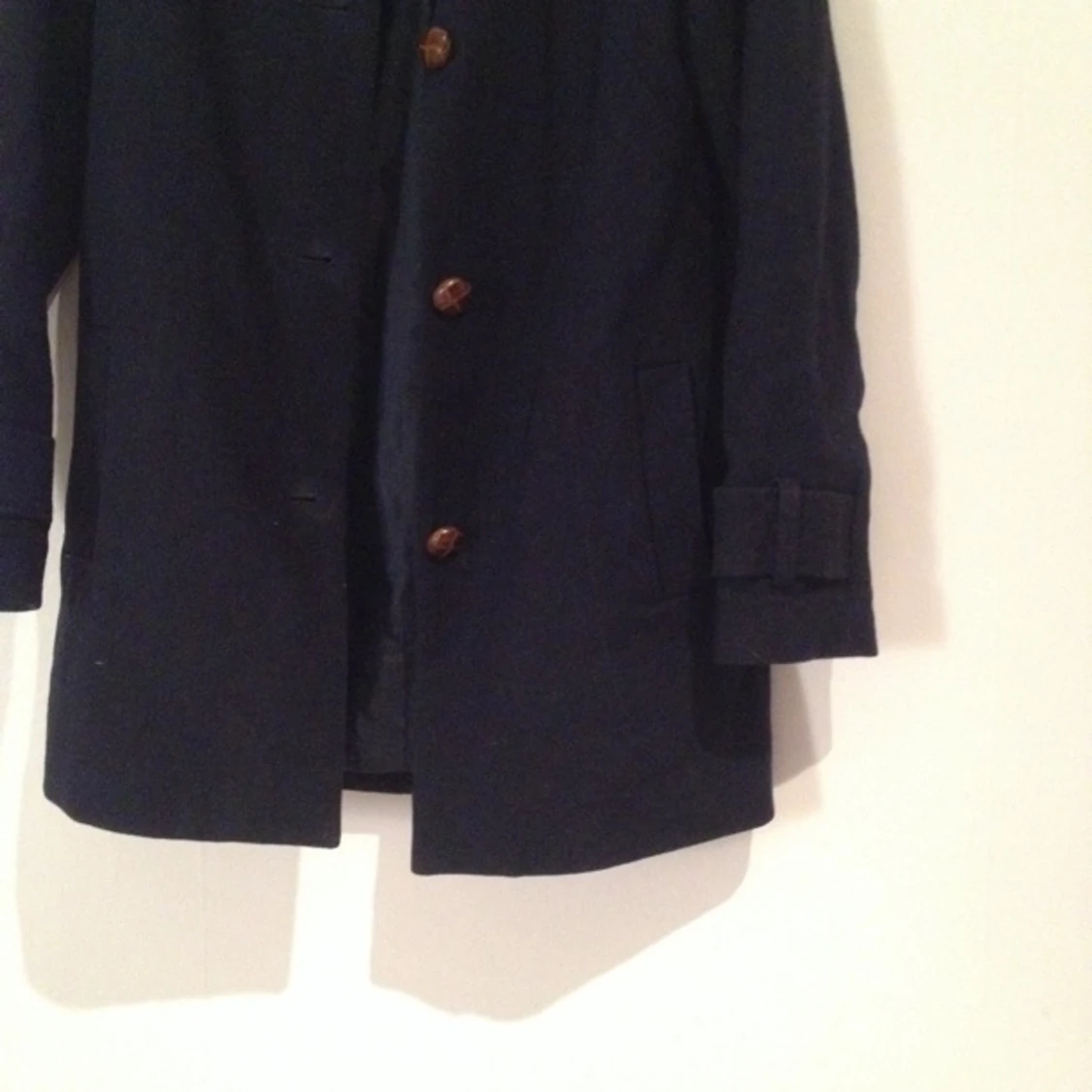 mörkt marinblå hm trend kappa med bruna stora knappar. 60% återvunnen ull, 30 polyester