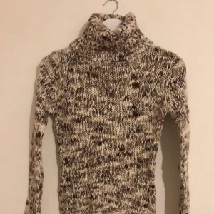  - Stickad polotröja i beige, vit och brun, lite 90-tal. 52% akryl, 48% ull. Storlek XS-S.
