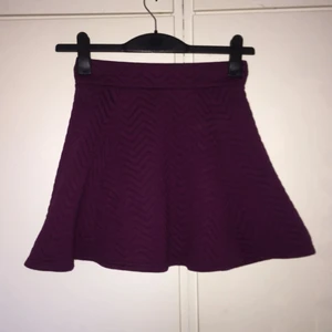  - Plommonfärgad klockad kjol från H&M. Tyget har en viss karaktär (se sista bilden). Strl 34. 