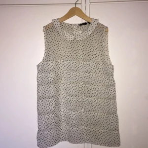  - Prickig blus från Lindex i strl 34. Krage och halv knäppning bak.