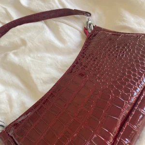 röd ormskinnsväska💖💖 - säljer min röda ormskinnsväska som nöstan aldrig kommit till andvändning❤️ frakten är inte inkluderad i priset ❤️