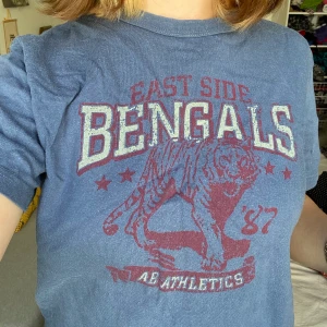 Blå T-shirt - Lite mindre T-shirt. Lite urtvättad därför sänkt pris men skitsnygg T-shirt  med Bengals tryck. Frakt tillkommer 