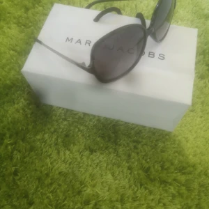 Marc By Marc Jacobs MMJ180/S Solglasögon - Snygga och klassiska solglasögon fr Marc By Marc Jacobs Modell : MMJ 180/S Färg: 0CVS Black Ruthenium (JJ gray shaded lens)Mått: 57-14-130 mm. Väldigt bra skick. Pris 1900 kr. Säljs 350 kr + Frakt (postens blå kuvert) Avhämtning i Södertälje el Fredhäll 
