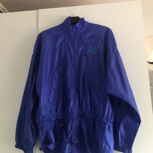 Vintage Nike windbreaker - Säljer en vintage Nike windbreaker som är köpt på beyond retro. Den har några fläckar som man kan se på bild två och tre. Men annars är den i relativt bra skick för att vara vintage. Den är i size S och jag kan släppa den för 150-200 kr. Frakt tillkommer