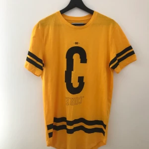 Snygg T-shirt  - Gulsvart t-shirt, helt oanvänd i bra kvalitet. Säljer pga att den aldrig har använts.