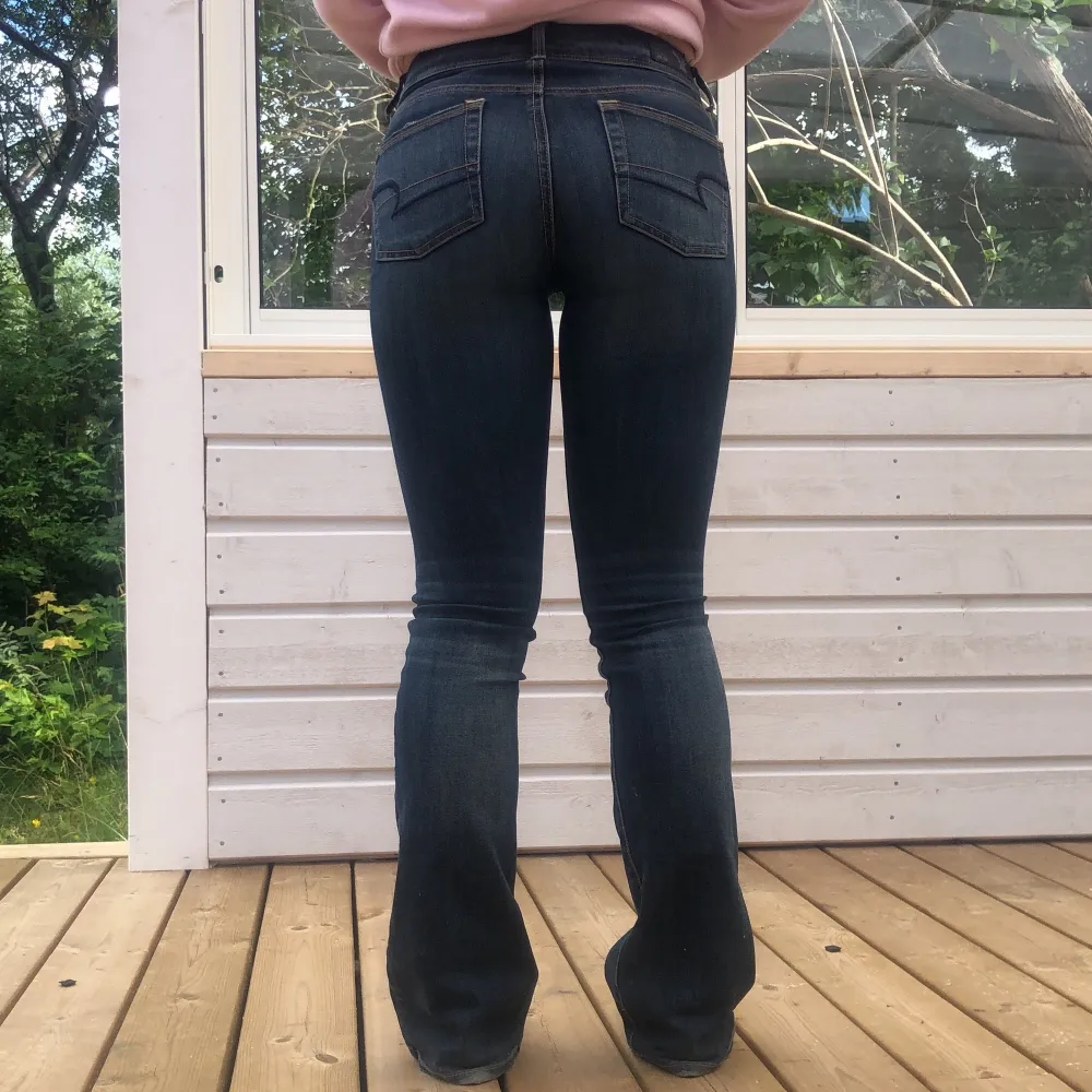 Ett par snygga bootcut jeans i mörkblå färg från American Eagle i storlek 00 regular (XS) Köpta för 600kr. Lågmidjade med en liten bootcut där nere. Jeans & Byxor.