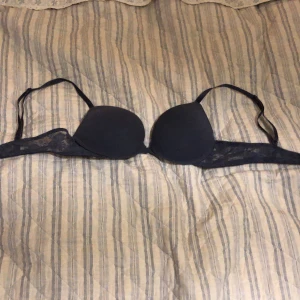 Bh blå - En bh i storlek 75A med minimalt pushup och spets på sidorna. Justerbara band men två haspar. Ingen spets på kupan.