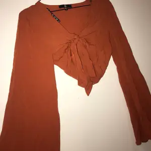 Knytblus i en orange/roströd jättefin färg. Vida ärmar