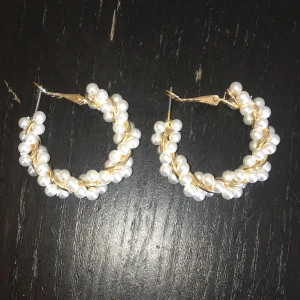 Runda örhängen - Fina runda örhängen i guld med små ostronpärlor runt (fake). OBS har sjukt små öron så örhängena ser större ut. Säljer pga för mycket smycken. Nypris ca 40:-