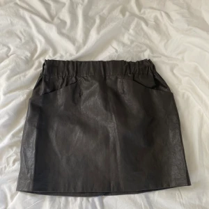 Läderkjol - En brun läderkjol från Zara som är helt oanvänd i storlek M. Säljer för 80kr