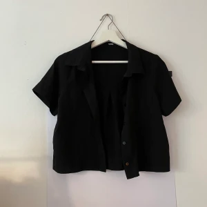 Kortärmad svart skjorta  - Sååå snygg kortärmad liten skjorta från BikBok som jag tyvärr ej kan ha längre. Endast använd en gång på nyår för ett par år sen så i mycket bra skick!