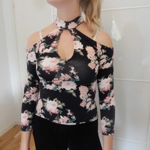 Blommig Tröja med choker - Fin blommig långärmad med inbyggd choker. Kan ej ha den pga för liten storlek. Har S och tröjan är storlek XS.