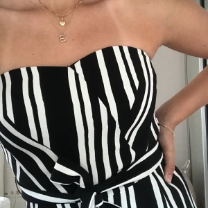 Jumpsuit från H&M strl 36 - Jumpsuit i vit och svarta ränder i strl 36. Använd 1 gång och är i gott skick. Säljs för 200 eller bud, köpt för cirka 500🤗