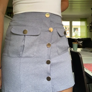 Jätte söt miniskirt - Lila/blå minikjol med guldfärgade knappar, fickorna är riktiga och går att använda! 40kr+frakt