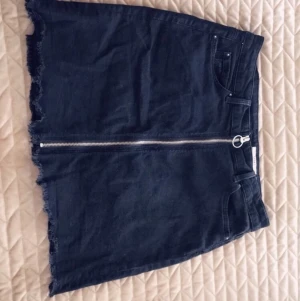 Jeanskjol  - Svart jeanskjol med en dragkedja som kan öppnas upp helt. Kjolen är från esprit och är strl 36