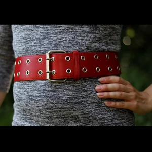 Rött skärp/bälte med silverdetaljer - Snyggt rött bälte med dubbla hål i silverdetaljer. Lätt att matcha, går att ha både i midjan som runt höfterna. Fint skick. Finns i Malmö, alt kan skickas (mot att köparen står för frakten). Betalning via swish.