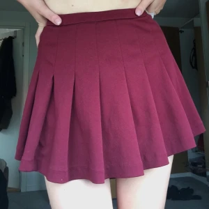 Cheerleaderkjol XS - Mörkröd cheerleaderkjol i fint skick. Med ficka på ena sidan! Superfin! Passar storlek XS. 85 kr + frakt 44 kr.