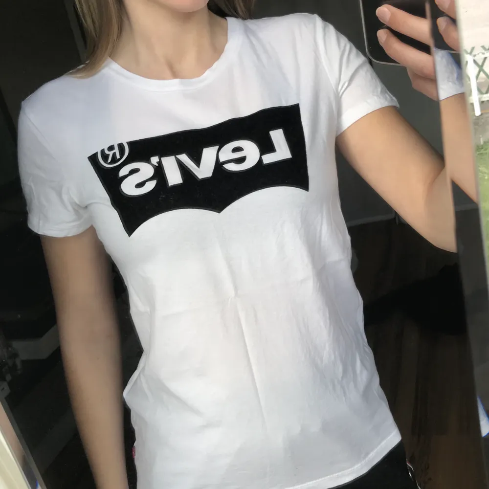 Vit Levis t-shirt med svart tryck. Trycket är i sånt mjukt material (?) Fint skick, i stort sett aldrig använd . T-shirts.