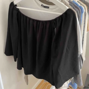 - Svart långärmad off shoulder tröja. Köpt utomlands därav inget märke. Tröjan är i bra skick och passar bra till lite kyligare sommarkvällar! Ärmarna är vida nedtill vilket ger en "flowing" effekt. Passar xs/s