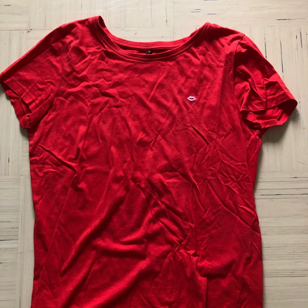 En fin, röd, somrig t-shirt med en rosa pussmun på! Härligt mjukt, material. Storlek S. Använd ett par gånger så det är en fin kvalitet på tröjan. . T-shirts.