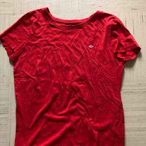 En fin, röd, somrig t-shirt med en rosa pussmun på! Härligt mjukt, material. Storlek S. Använd ett par gånger så det är en fin kvalitet på tröjan. 