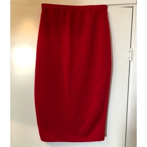 Röd midjekjol - Röd midjekjol med resår i midjan. Stretchigt material. Går nedanför knäna. Aldrig använd!