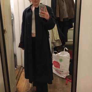  - Blå kappa med rödrutig insida. Gott skick! Köpt på second hand men har personligen aldrig använt den. Storlek inte angiven men skulle gissa M/L. Veckad i ryggen och har bälte. 