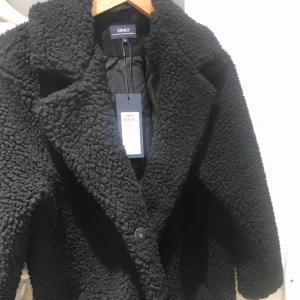  - En svart kappa som är köpt från only