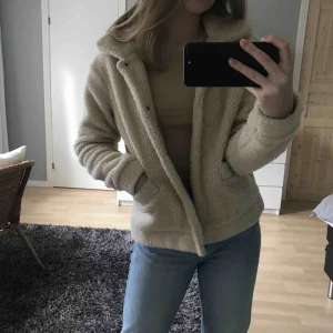  - Asmysig teddyjacka, ljusbeige/vit. Sparsamt använd (frakt tillkommer)