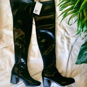 Lårhöga stövlar i pleather - Populära lårhöga stövlar från Monki i storlek 38. Väldigt bekväma att gå i (brukar jobba i mina!). Oanvända med prislapp kvar. Kostar 600 kr i nypris. Säljes pga fel storlek. Väldigt snygga på, går upp till mitten av låret ungefär och sitter som smäck. Kan mötas upp eller frakta!🌸