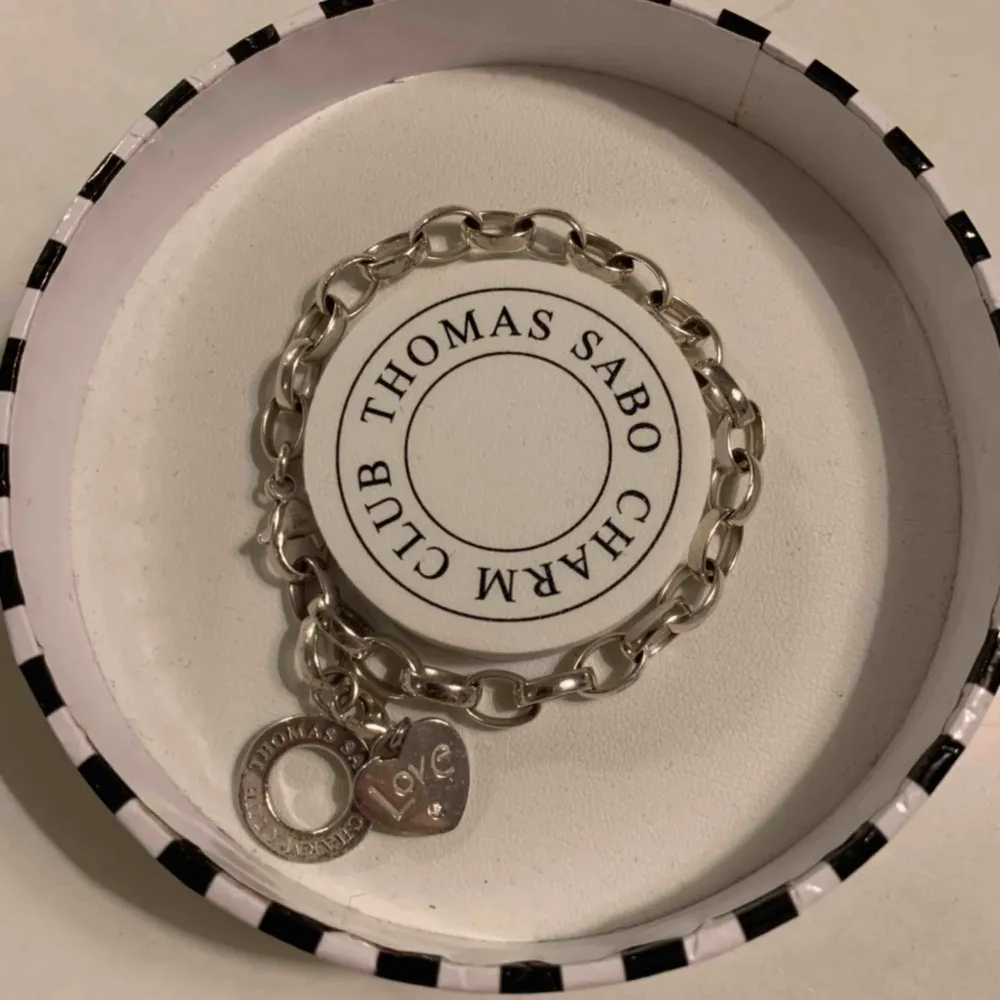 Thomas Sabo armband i silver med tillköpt berlock. Berlocken föreställer ett hjärta som det står ”Love” på. Asken medföljer! Köparen står för frakten.. Accessoarer.