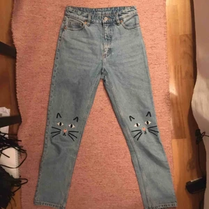  - Söta jeans med broderade kattansikten på. Skulle kunna klippas till shorts också. Tyvärr för korta för mig (jag är 174 cm). De  är i ljust denim och bra skick💖 Möts i Stockholm eller fraktar!