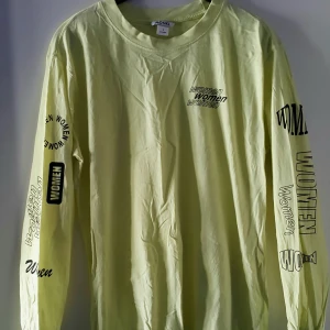 Monki tröja - Ljus neon gul/grön tröja med tryck från Monki. Aldrig använd, endast tvättad så i fint skick. Storlek S men lite oversized i modellen. Fraktkostnad blir 47kr.