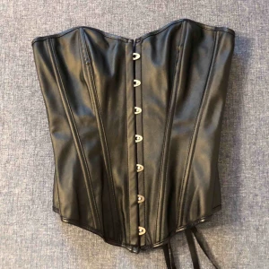  - Svart korsett i läderimitation. 