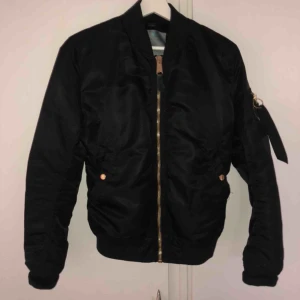  - Superfin Bomberjacka från Alpha Industries med gulddetaljer. Nypris 1799kr.