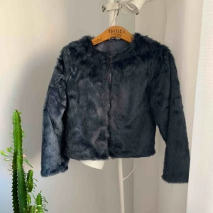  - Petrolblå jacka. Relativt tunn. Fuskpäls. Storlek XS