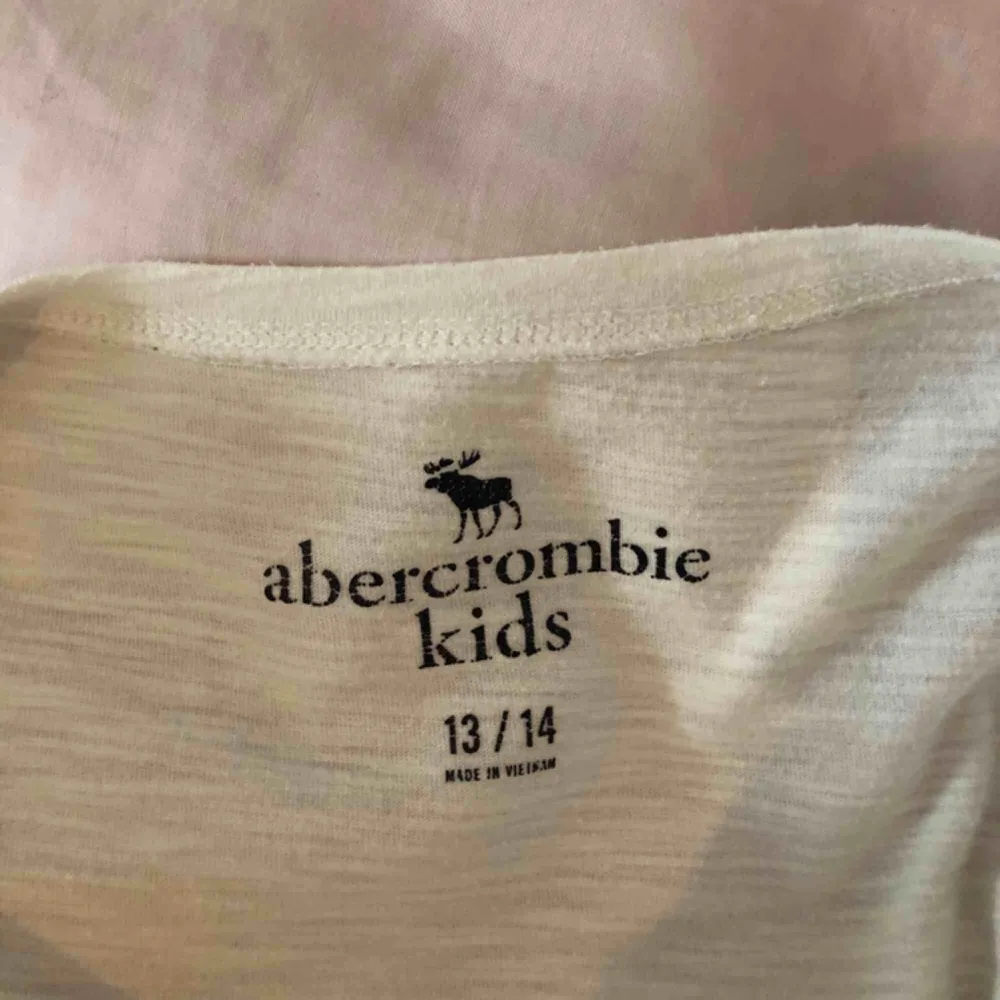 Vit tshirt från abercrombie & fitch, köpt i new york. Storlek 13/14 år och passar mig med xs. Den är i bra skick, säljer för jag har många liknande t-shirts. . T-shirts.