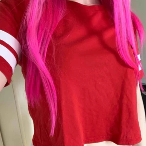  - En röd t-shirt som går över naveln. 