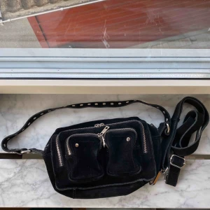  - Svart Nunoo väska. Köpt för ca 1 år sen och har lite slitningar men fortfarande i ett hyfsat skick. Långt band medföljer. Vid frakt tillkommer en kostnad på 80 kr😇