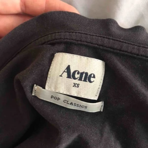  - Grå/Svart Acne tisha med volang i kragen