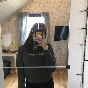  - En grön campion hoddie med luva