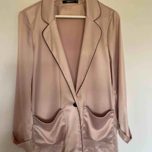  - Blazer/kavaj i gammelrosa satin. Storlek 40. Använd fåtal gånger. Skickas spårbart och fraktkostnad på 63kr tillkommer!