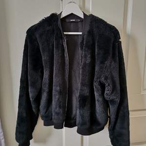 En jacka/tröja i fluffigt svart material 
