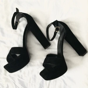  - Säljer ett par fina klackskor från Nelly. Det är svart mockaimitation. 14cm klack. Helt oanvända. Väldigt fina och stilrena! 