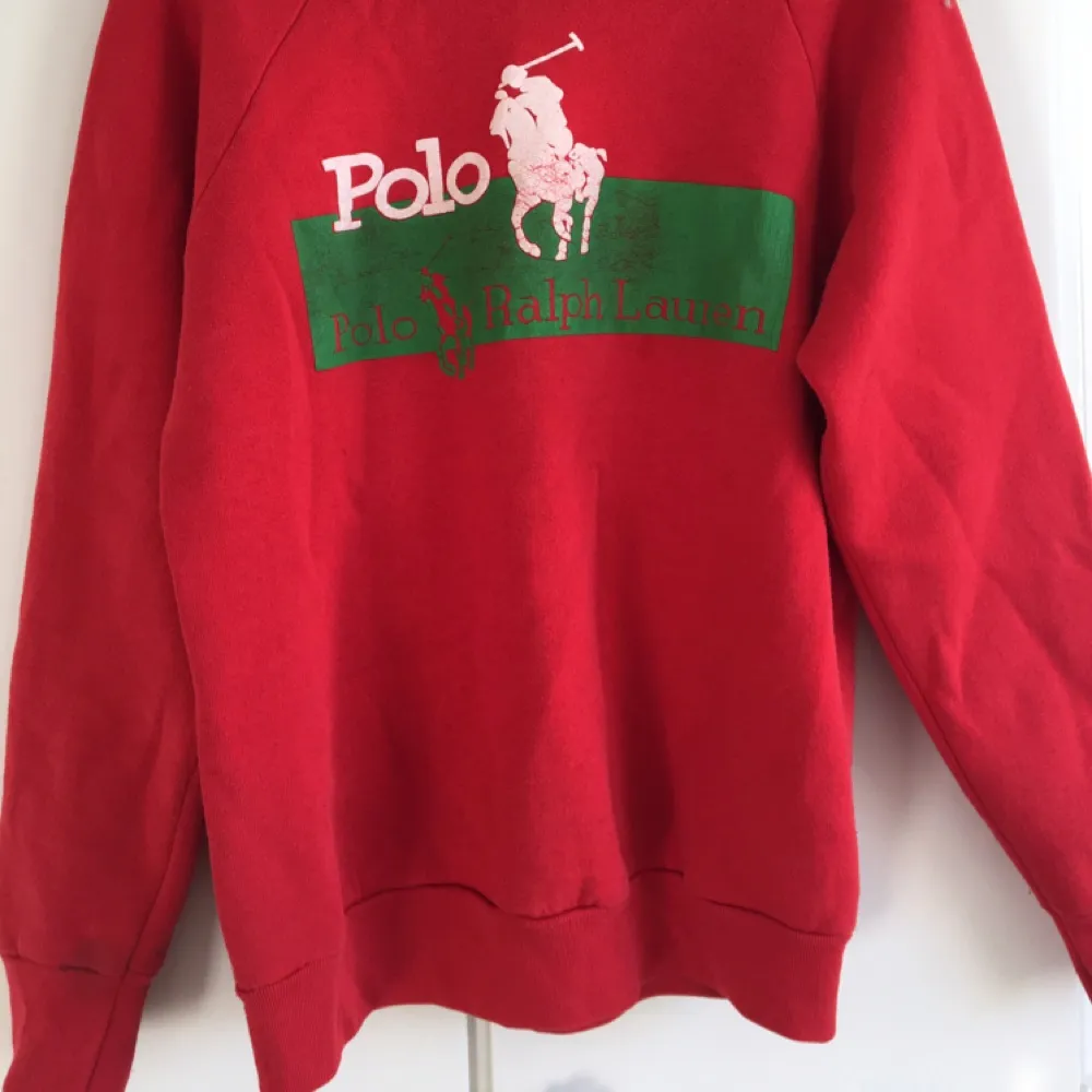 En knall röd sweatshirt med Polo Ralph Lauren tryck, den är inte äkta vilken man kan se på sista bilden. På lappen står det L, men tröjan är nog mer en M! . Hoodies.